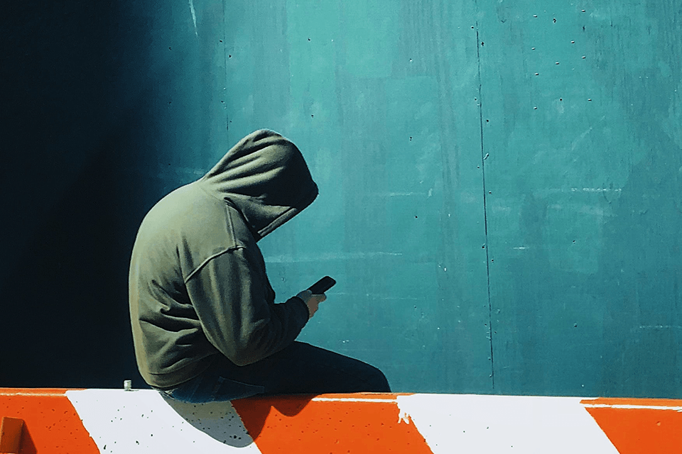 Hooded Teen using cell phone